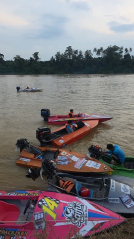 Bot lumba berbaris di tebing sungai waktu senja